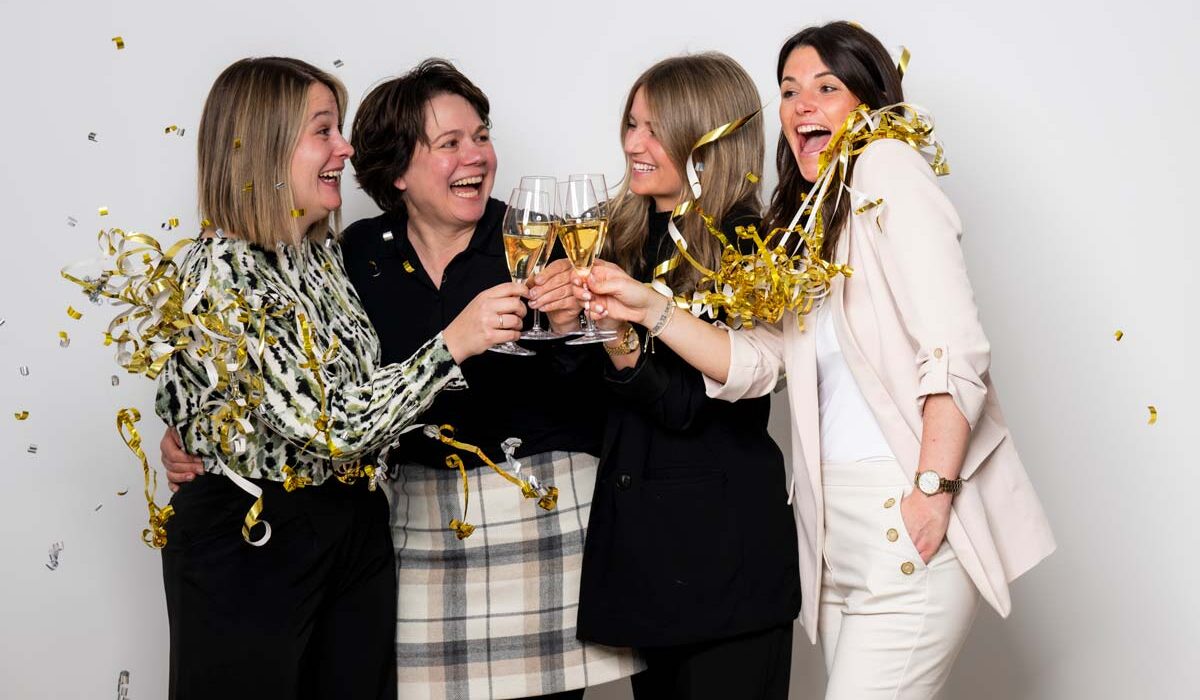 Team SCHÖNES LEBEN Gruppe Frauen mit Sekt und Partyschlangen